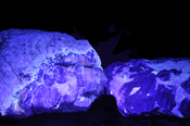 Afghanite viewed under ultra-violet light. Calcite emits rose light as Afghanite, Lazurite doesn't emit visible light.