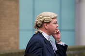 English: A barrister on a mobile phone outside Southwark Crown Court.
