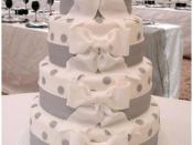 A contemporary white wedding cake decorated with sugar bows.