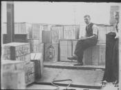 This black and white photo shows a tally clerk sitting with a truck load of beer cases. These cases were the first consignment of liquor following the lifting of Prohibition in the (then) Federal Capital Territory.