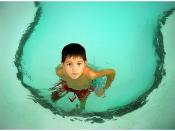A boy in a children's swimming pool.