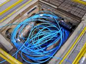 English: Fibre-optic cable and two fibre splicers in a Telstra pit/duct.