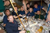 The crews of STS-127 and Expedition 20 enjoy a meal inside Unity.