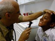 English: GEORGETOWN, Guyana (Sept. 26, 2007) - Cmdr. Arne Anderson, a pediatrician attached to Military Sealift Command hospital ship USNS Comfort (T-AH 20), examines a patient’s teeth at the Project Dawn at Liliendaal care site. Comfort is on a fou