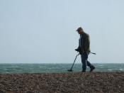 Man with metal detector on the Brighton Beach.