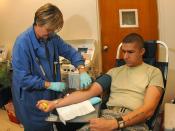 English: OFFUTT AIR FORCE BASE, Neb.,- Mrs. Audrey Flekke from the American Red Cross checks on Airman 1st Class Evan Cater, a medical record technician from the 55th Medical Operations Squadron, while he donates blood Nov. 07. Airman Cater is known as a 