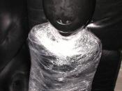 The picture shows a female bottom in a sensory deprivation by an inflatable latex hood