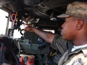 English: CAMP LIBERTY, Iraq - Spc. Edric Ashley, a light-wheel vehicle mechanic, assigned to quality control and assurance, Division Special Troops Battalion, 1st Cavalry Division, indicates where the switch that activates the windshield wipers is found w