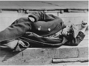 English: Great Depression: man dressed in worn coat lying down on pier, New York City docks. (53227(2060), 00/00/1935, 27-0622a.gif)