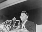 Elijah Muhammad standing behind microphones at podium / World Telegram & Sun photo by Stanley Wolfson.