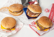 English: A selection of value-menu hamburgers from American fast food chains. Clockwise from left to right: McDonald's McDouble, Burger King Buck Double, Sonic Drive-In Jr. Deluxe Burger, Wendy's Double Stack.
