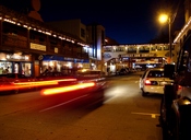 Cannery Row at Night. Dusk over the city of Monterey on Cannery Row (formerly Ocean Ave.) as cars pass by while City police investigate a vehicle blocking a hotel entrance. On the street in front of the south end of, 652 Cannery Row, Monterey, CA 93940.