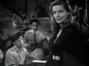 Cropped screenshot of Lauren Bacall, with Hoagy Carmichael in the background playing piano, from the trailer for the film To Have and Have Not.