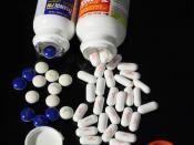 Open bottles of Extra Strength Tylenol and Extra Strength Tylenol PM, pain relievers with the active ingredient acetaminophen/paracetamol. Tylenol PM (the white-and-blue tablets) also contains diphenhydramine, a sleep aid. These drugs were made by McNeil-