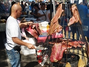 English: Spit barbecue meat hanging on Avenue C in the East Village (Loisaida section) during a street fair