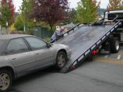 English: A car being loaded onto a flatbed tow truck
