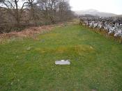 English: The Cout of Keilder's Grave This low grass mound is labelled as the Cout of Keilder's Grave, traditionally the grave of a Tynedale Baron who terrorised these lands util he was drowned in the nearby Hermitage Water. Stands alongside Hermitage Chap