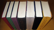 All seven books in the Harry Potter series in order without their dust jackets. Each hardcover book used a different two-color scheme. The books are the first American editions published by Scholastic. Author's collection.