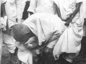 English: Gandhi at Dandi, South Gujarat, picking salt on the beach at the end of the Salt March, 5 April 1930. Behind him is his second son Manilal Gandhi and Mithuben Petit Français : Gandhi at Dandi, sud du Gujarat, ramassant du sel sur la plage le 5 av