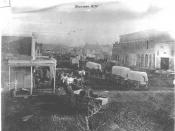 English: Title: Bozeman Main Street, 1875 Creator: Brook, Thomas B. Date: 1873 Description: Long line of covered freight wagons stretching down the dirt main street of Bozeman past the town's first brick building. Same as image 183 in the Picture Collecti