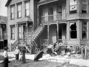 English: a house with broken windows and debris in the front yard during a race riot in Chicago, Illinois. Two young white boys are standing in front of the house and looking at it.