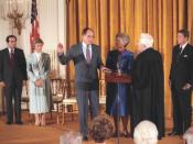 English: Justice William Rehnquist is sworn in as Chief Justice by his predecessor, Warren Burger as Judge and Mrs. Antonin Scalia and President Ronald Reagan look on.