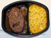 A modern TV dinner with Salisbury steak and macaroni and cheese.