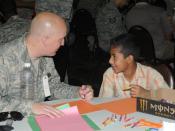 English: Air Force Tech. Sgt. Josh A. Sallee, the logistics civil augmentation program requirements manager for the 332nd Expeditionary Civil Engineer Squadron, and a Lake Geneva, Wis., native, colors with the child he is mentoring Oct. 10 at Iraqi Kids' 