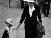 English: Mother and child at the show, 1938. Both mother and toddler daughter wear bonnets and carry coats.