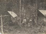 English: Loggers at their camp in the Bunya Mountains, 1912 Group of three men are pictured outside two tents. They are surrounded by bush.