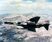 An F-4G Phantom II aircraft shows its undercarriage holding four different missiles: one each AGM-45, AGM-65, AGM-78, AND AGM-88.