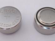 English: Two identical LR44 button cell alkaline batteries (showing top side and underside). Also known as LR1154, AG13, A76, 157 (alkaline), SG13, S76, 1166A