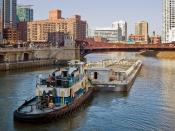 A tugboat pushing a barge westward along the main stem of the Chicago River