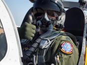 Author (User:BQZip01) in a jet wearing appropriate flight gear to include an MBU-20 oxygen mask, helmet, flight suit, flight gloves, and parachute.