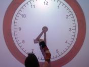 Nederlands: Een leerling zet op het digibord een klok op de juiste tijd tijdens een les klokkijken.