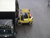 photo of a fork-lift truck about to lift boxes from a lorry. Taken at the NEC, West Midlands, England.