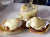Eggs Benedict consisting of “English muffins topped with Canadian bacon, poached eggs & hollandaise sauce” with their house potatoes in the background, as served at Orange in Chicago, Illinois, according to their online menu as viewed on 2007-05-29.
