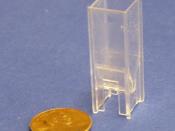This plastic cuvette is used in a spectrophotometer to measure DNA and RNA concentrations. A United States cent (19 mm diameter) is included for scale.