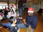 English: SASEBO, Japan (Dec. 18, 2009) Religious Program Specialist 2nd Class Josia Onyango plays with a child during a holiday community service project at the Kusuzumi daycare center where Sailors from Fleet Activities Sasebo played with the children an