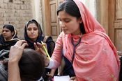 Flickr - DFID - A female doctor with the International Medical Corps examines a woman patient at a mobile health clinic in Pakistan