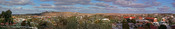 English: Panoramic view of the main section of the town of Broken Hill, NSW, Australia. Behind the town centre can be seen the man-made mullock heaps built from the waste rock from the Line of Lode Mine that dissects the town (the mullock heaps are the 'h