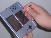 English: This image is a photograph of myself holding a Nintendo DS sideways, a feature used in some games for the system. The system is held sideways with one hand, while the other holds the stylus.