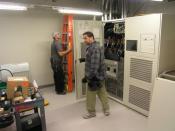 English: Large UPS (Uninterruptible Power Supply) being installed in a Datacenter. This unit has a 500kVA capacity. Electricians provide scale for size.
