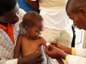 Medical staff examine a child for signs of malnourishment in DRC