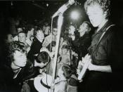 Warner Bros. promotional picture of the Sex Pistols, in performance at the 100 Club, 1976. On the right: Steve Jones (foreground) and Johnny Rotten (background)..