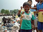English: A boy from an East Cipinang trash dump slum shows his find, Jakarta Indonesia.