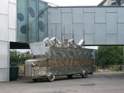 English: I accuse the oil companies... When I first saw the slogan on the side of this splendid mock armoured vehicle in the grounds of the Stephen Lawrence centre I thought it had been prepared for 'climate change' protests, but then I saw the name Ken S