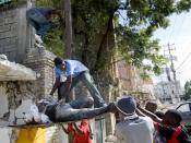 Haitians pull out a body from the rubbles of a school that collapsed after the earthquake that rocked Port au Prince on January 12. Photo Marco Dormino/ The United Nations