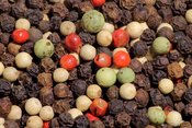 English: A mixture of black peppercorns from the Malabar Coast, white Muntok peppercorns from Bangka, China, green peppercorns from Brazil, and pink peppercorns (berries of the Baies rose plant, Schinus terebinthifolius) from Réunion (France). Packaged as