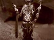 A Diné man, full-length, in ceremonial dress including mask and body paint.